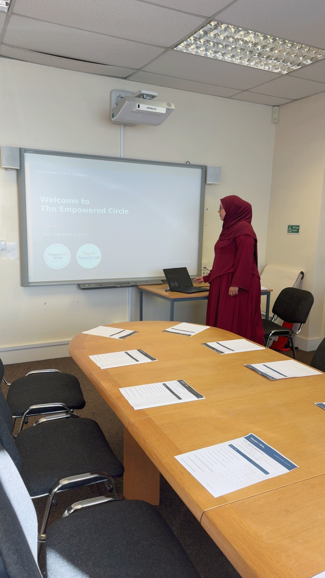 Sofia introducing an EmpowerED Minds Circle session beside the presentation screen